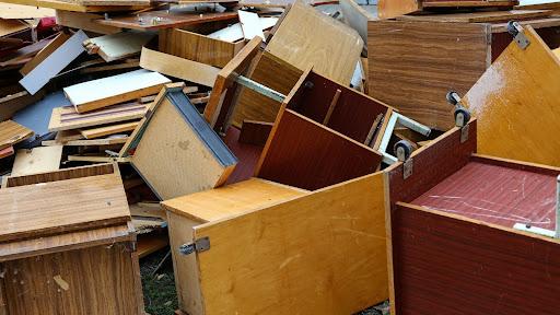A collection of used wooden office furniture that is going to be recycled.
